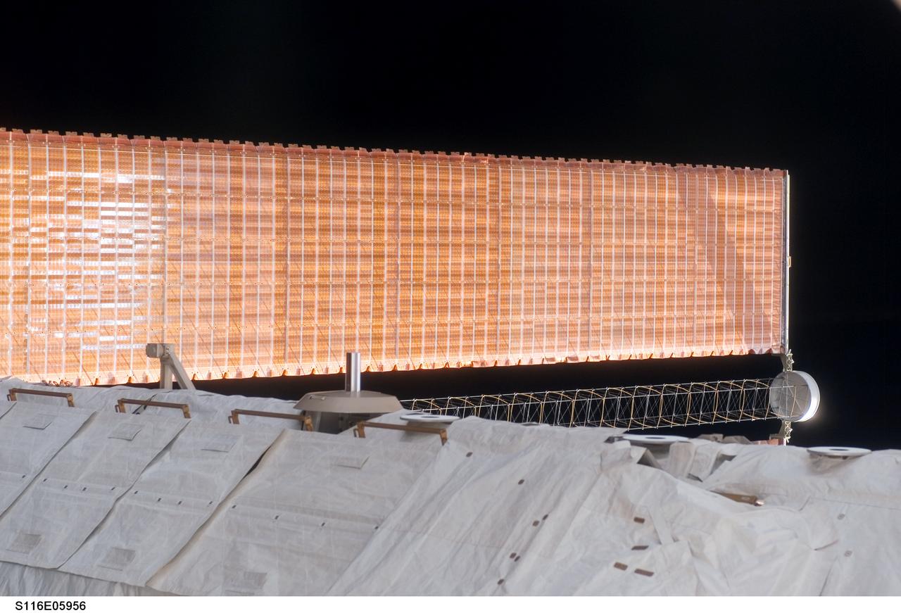 S116-E-05956 (12 Dec. 2006) --- A medium close-up view of a solar array wing panel was photographed by a STS-116 crewmember during the mission's first of three planned sessions of extravehicular activity (EVA) as construction resumes on the International Space Station.