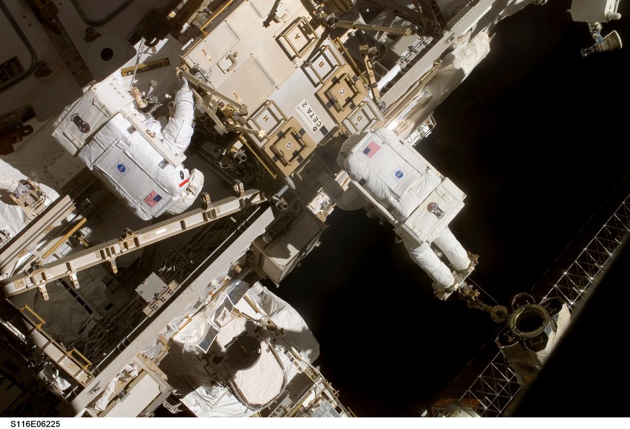 S116-E-06225 (14 Dec. 2006) --- Anchored to the International Space Station's Canadarm2 foot restraint, European Space Agency (ESA) astronaut Christer Fuglesang (right), STS-116 mission specialist, works in tandem with astronaut Robert L. Curbeam, Jr., mission specialist, during the mission's second of three planned sessions of extravehicular activity (EVA) as construction resumes on the station.