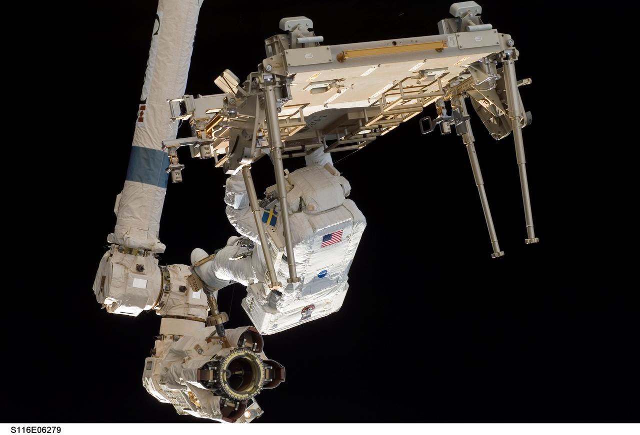 S116-E-06279 (14 Dec. 2006) --- With his feet secured on the Canadarm2,  European Space Agency astronaut Christer Fuglesang, STS-116 mission specialist, works to relocate one of the two Crew Equipment Translation Aid (CETA) carts during EVA 2 on Dec. 14.  Astronaut Robert L. Curbeam Jr., who is sharing two spacewalks with Fuglesang on this flight, is out of frame.