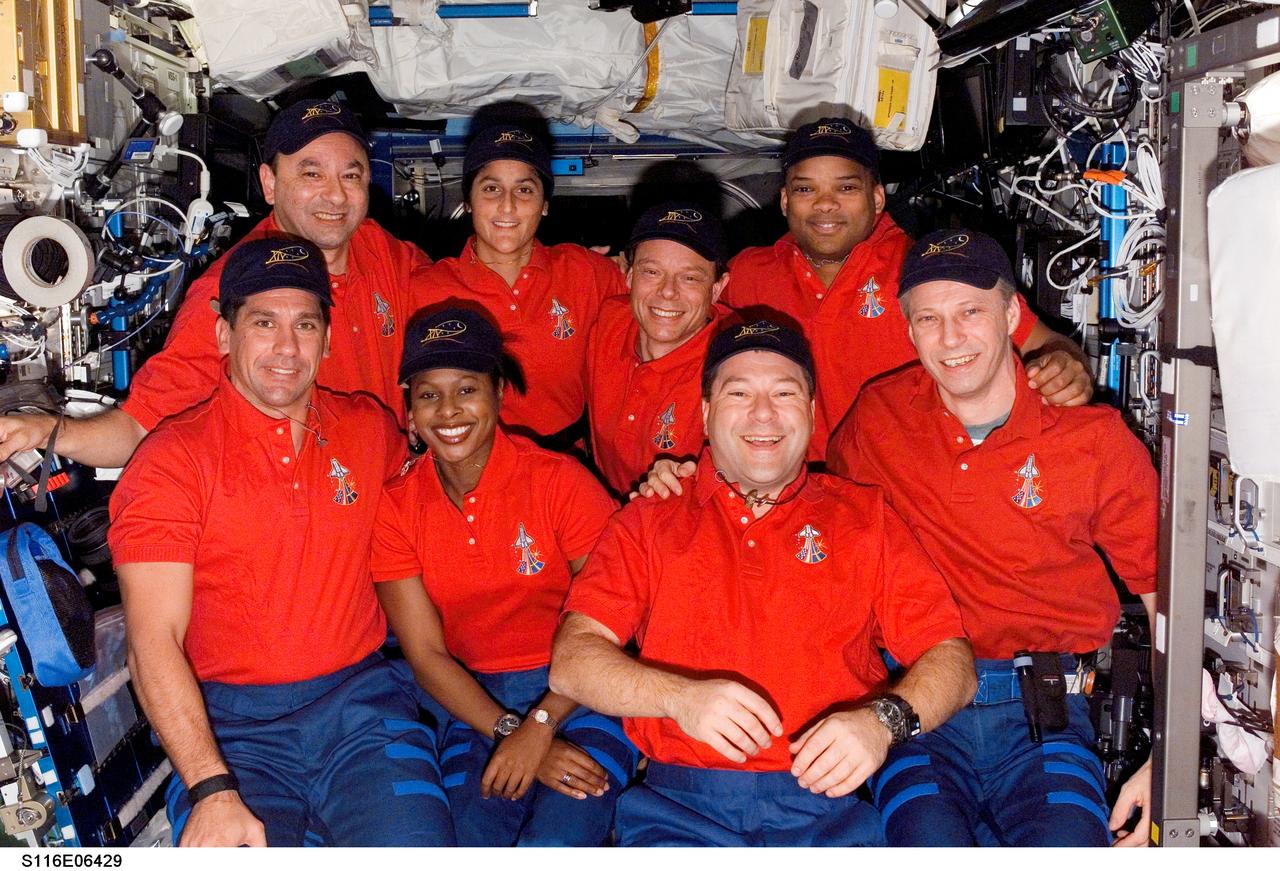 S116-E-06429 (15 Dec. 2006) --- The STS-116 crewmembers gather for a group portrait during a joint crew press conference in the Destiny laboratory of the International Space Station while Space Shuttle Discovery was docked with the station. From the left (front row) are astronauts William A. (Bill) Oefelein, pilot; Joan E. Higginbotham, Nicholas J. M. Patrick and European Space Agency (ESA) astronaut Thomas Reiter, mission specialists. From the left (back row) are astronauts Mark L. Polansky, commander; Sunita L. Williams, Expedition 14 flight engineer; European Space Agency (ESA) astronaut Christer Fuglesang and Robert L. Curbeam, Jr., mission specialists. Shortly after the two spacecraft docked on Dec. 11, Williams became a member of the station crew. At the same time, Reiter became a Discovery crewmember for his ride home, completing about six months in space.