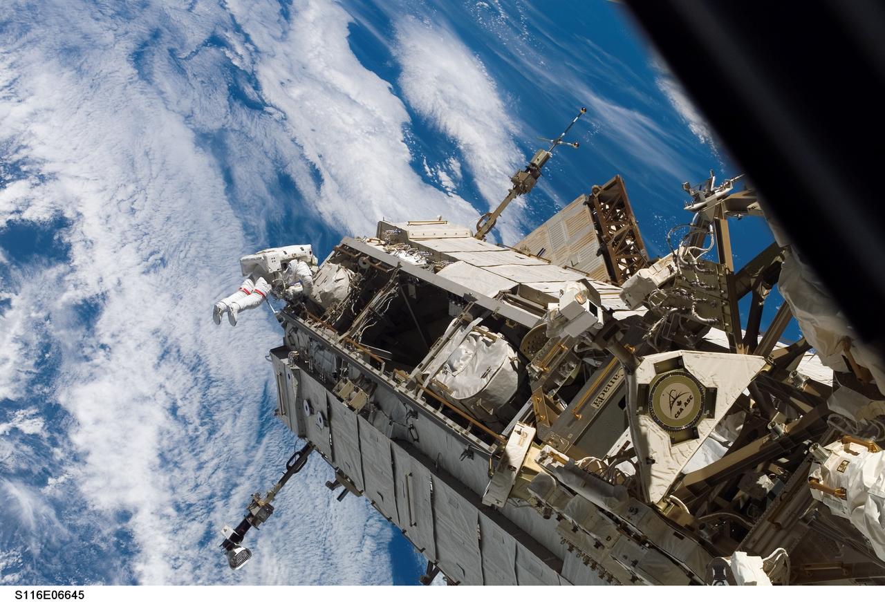 S116-E-06645 (16 Dec. 2006) --- Astronaut Robert L. Curbeam, Jr., STS-116 mission specialist, participates in the mission's third planned session of extravehicular activity (EVA) as construction resumes on the International Space Station. Astronaut Sunita L. Williams, (out of frame), STS-116 mission specialist, also participated in the 7-hour, 31-minute spacewalk. A blue and white Earth provides the backdrop for the scene.