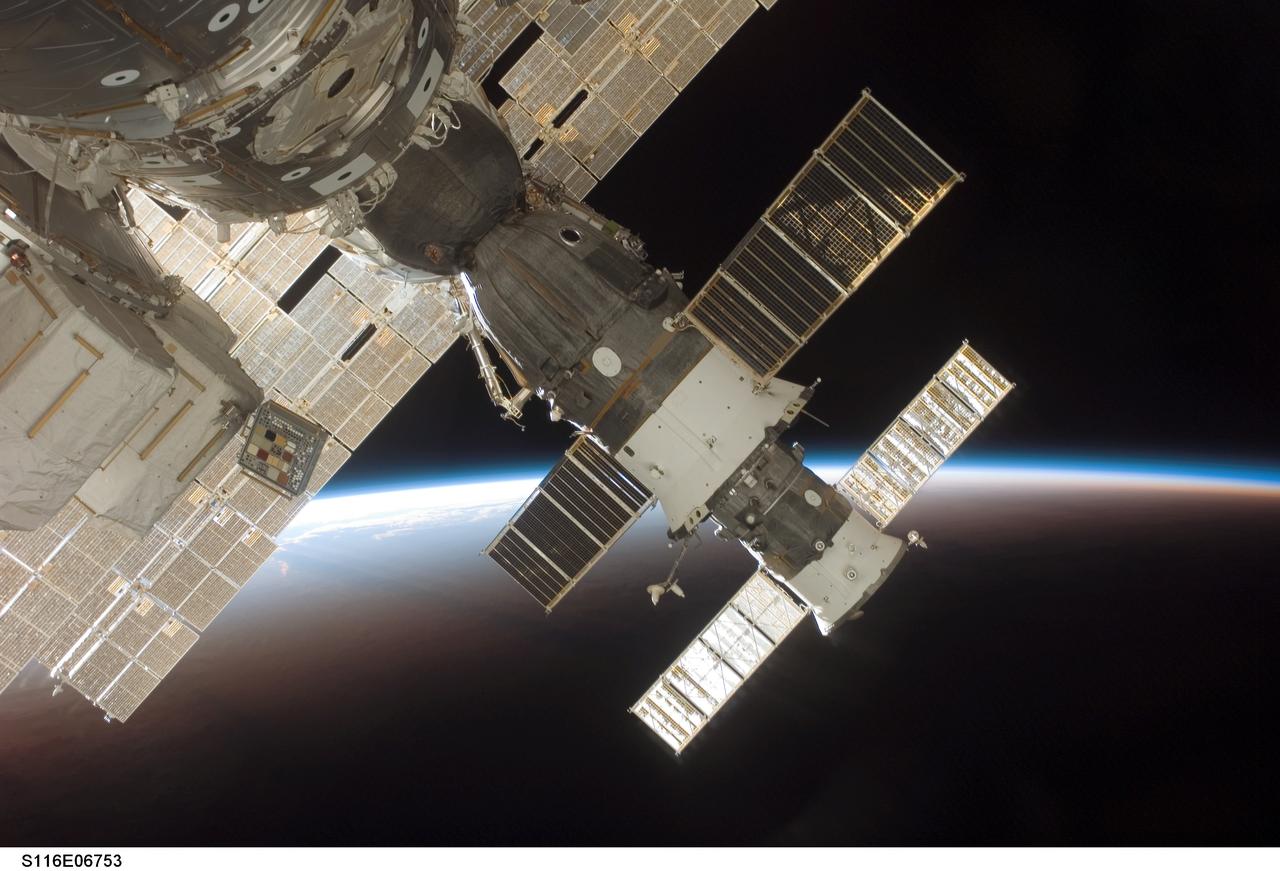 S116-E-06753 (17 Dec. 2006) --- The docked Soyuz 13 (TMA-9) (foreground) and Progress 22 resupply vehicle are featured in this image photographed by a STS-116 crewmember from a window on the International Space Station while Space Shuttle Discovery was docked with the station. The blackness of space and Earth's horizon provide the backdrop for the scene.