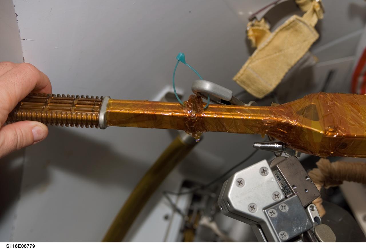 S116-E-06779 (18 Dec. 2006) --- A view of a cheater bar assembly wrapped in insulating tape onboard Space Shuttle Discovery, scheduled for use during STS-116 extravehicular activity (EVA) as construction resumes on the International Space Station.