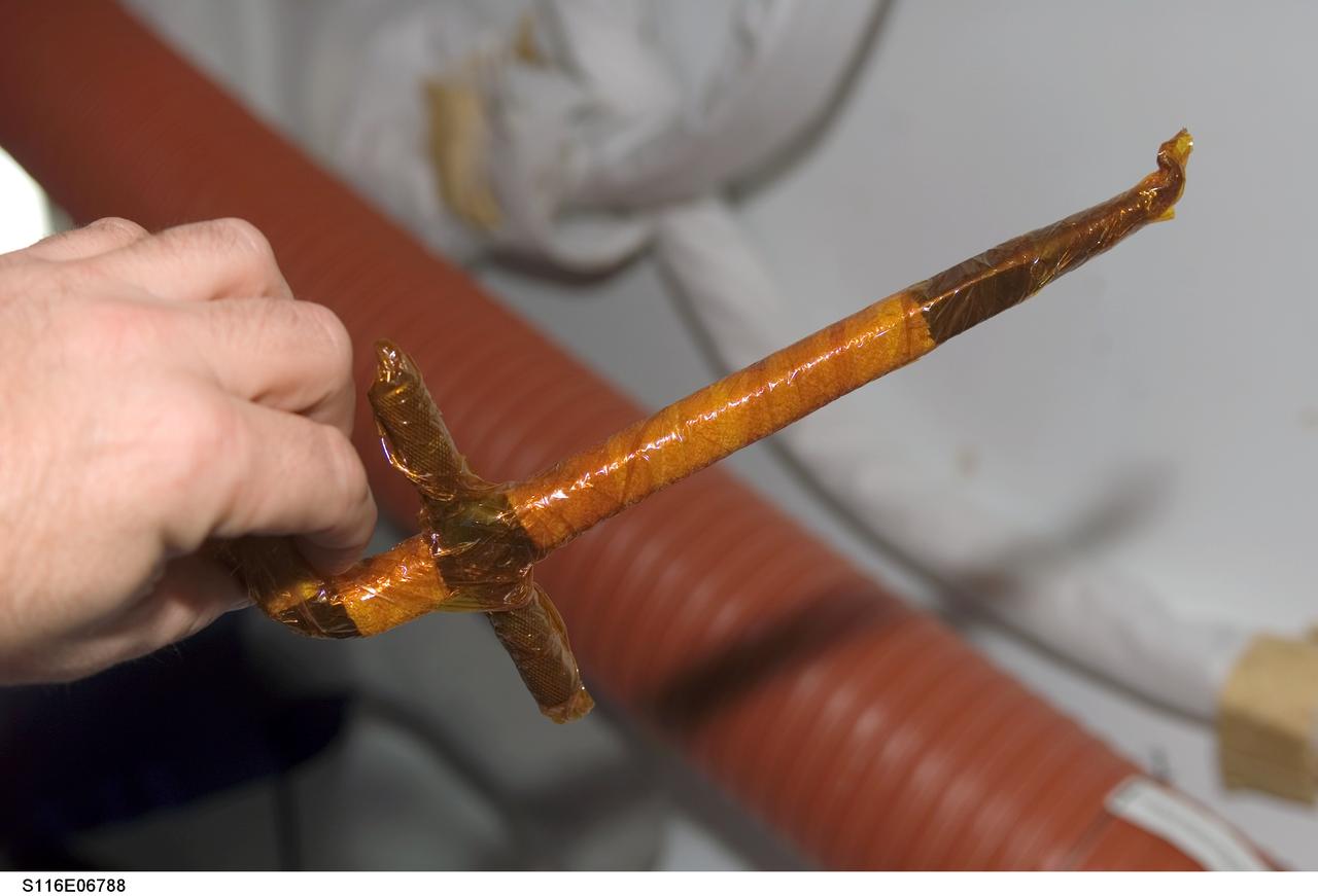 S116-E-06788 (18 Dec. 2006) --- A view of a loop-pin-puller wrapped in insulating tape onboard Space Shuttle Discovery, scheduled for use during STS-116 extravehicular activity (EVA) as construction resumes on the International Space Station.