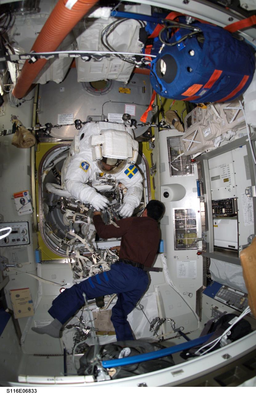 S116-E-06833 (18 Dec. 2006) --- European Space Agency (ESA) astronaut Christer Fuglesang, STS-116 mission specialist, moves into the outer section of the Quest Airlock of the International Space Station as he prepares for the mission's fourth session of extravehicular activity (EVA) while Space Shuttle Discovery was docked with the station. Astronaut William A. (Bill) Oefelein, pilot, assisted Fuglesang.