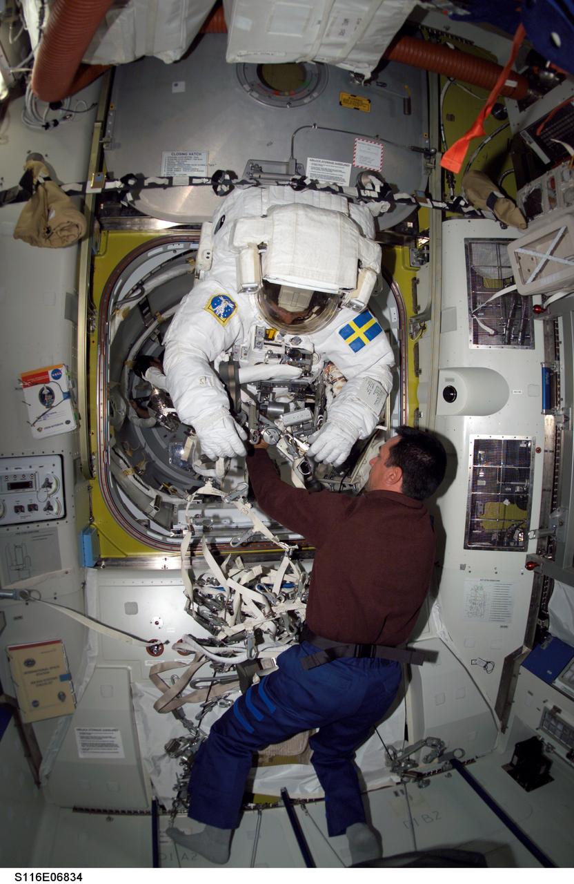 S116-E-06834 (18 Dec. 2006) --- European Space Agency (ESA) astronaut Christer Fuglesang, STS-116 mission specialist, moves into the outer section of the Quest Airlock of the International Space Station as he prepares for the mission's fourth session of extravehicular activity (EVA) while Space Shuttle Discovery was docked with the station. Astronaut William A. (Bill) Oefelein, pilot, assisted Fuglesang.