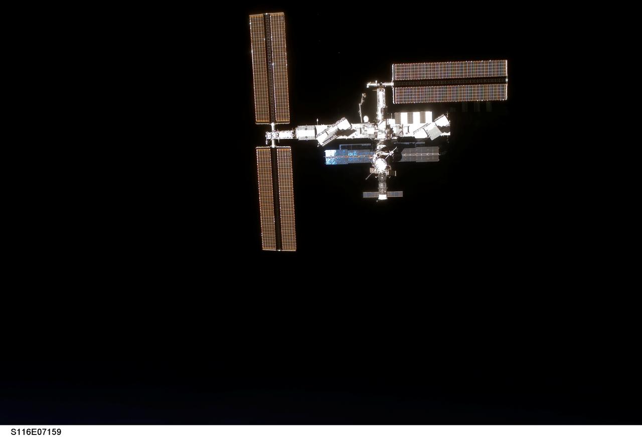 S116-E-07159 (19 Dec. 2006) --- Backdropped by the blackness of space, the International Space Station moves away from Space Shuttle Discovery. Earlier the STS-116 and Expedition 14 crews concluded eight days of cooperative work onboard the shuttle and station. Undocking of the two spacecraft occurred at 4:10 p.m. (CST) on Dec. 19, 2006. Astronaut William A. (Bill) Oefelein, STS-116 pilot, was at the controls for the fly-around, which gave Discovery's crew a look at its handiwork, a new P5 spacer truss segment and a fully retracted P6 solar array wing. During their stay on orbital outpost, the combined crew installed the newest piece of the station's backbone and completely rewired the power grid over the course of four spacewalks.