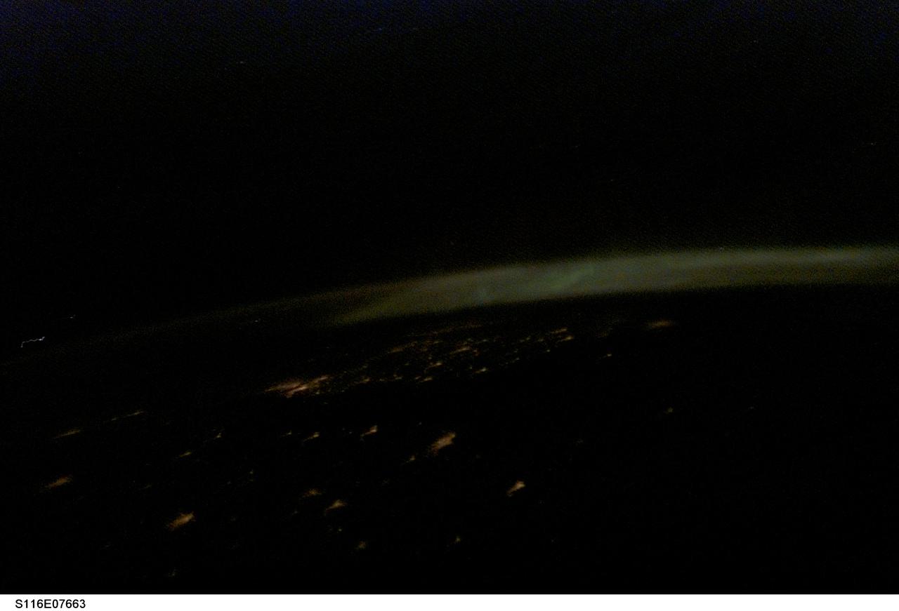 S116-E-07663 (20 Dec. 2006) --- One of the STS-116 crewmembers onboard the Space Shuttle Discovery captured this picture of Aurora Borealis over Norway, Poland and Sweden, as the crew made preparations for a Dec. 22 landing. European Space Agency astronaut Christer Fuglesang onboard the shuttle noted the rarity of pictures over this area from shuttle missions, and especially pictures that included the Northern Lights.  Fuglesang is from Sweden. The city lights of Copenhagen (bright cluster of lights in the middle left portion of the image), Stockholm (under the aurora on the far right side of the image), and Gdansk (in the center forefront) are seen. The formation of the aurora starts with the sun releasing solar particles.  The Earth's magnetic field captures and channels the solar particles toward the Earth's two magnetic poles (north and south). As the solar particles move towards the poles they collide with the Earth's atmosphere, which acts as an effective shield against these deadly particles.  The collision between the solar particles and the atmospheric gas molecule emits a light particle (photon).  When there are many collisions the aurora is formed.