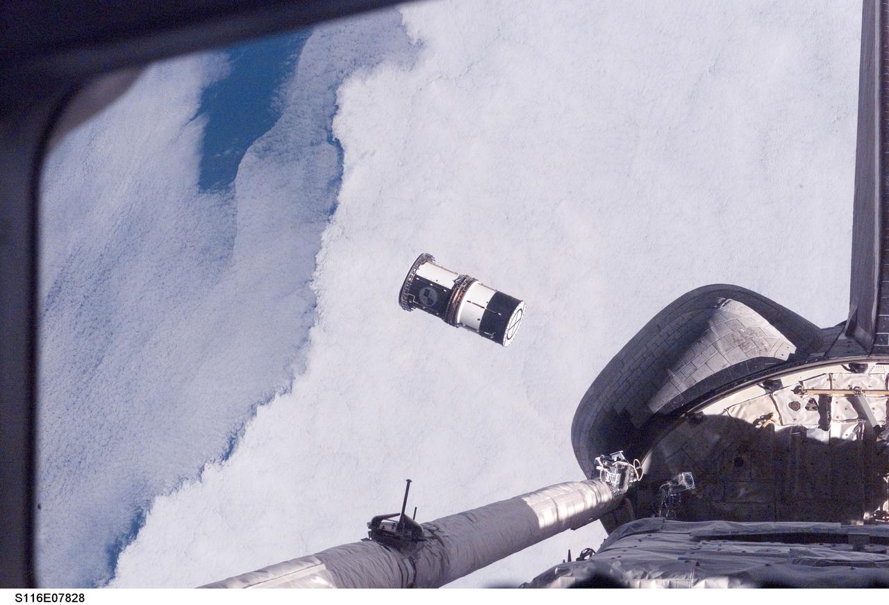 S116-E-07828 (21 Dec. 2006) --- As seen through windows on the aft flight deck of Space Shuttle Discovery, a Department of Defense pico-satellite known as Atmospheric Neutral Density Experiment (ANDE) is released from the shuttle's payload bay by STS-116 crewmembers. ANDE consists of two micro-satellites which will measure the density and composition of the low Earth orbit (LEO) atmosphere while being tracked from the ground. The data will be used to better predict the movement of objects in orbit.