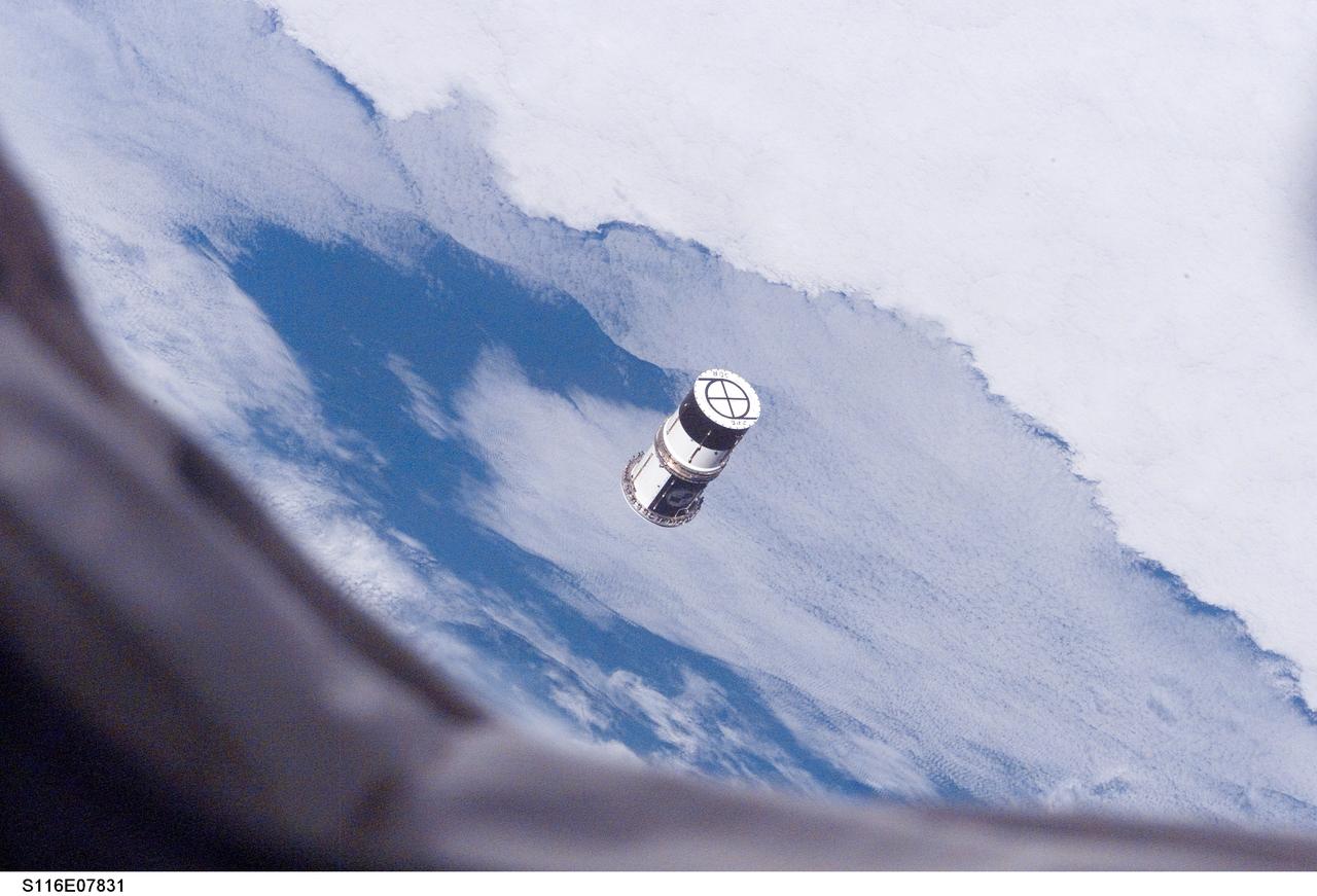 S116-E-07831 (21 Dec. 2006) --- As seen through windows on the aft flight deck of Space Shuttle Discovery, a Department of Defense pico-satellite known as Atmospheric Neutral Density Experiment (ANDE) is released from the shuttle's payload bay by STS-116 crewmembers. ANDE consists of two micro-satellites which will measure the density and composition of the low Earth orbit (LEO) atmosphere while being tracked from the ground. The data will be used to better predict the movement of objects in orbit.