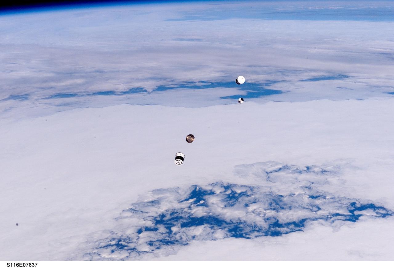 S116-E-07837 (21 Dec. 2006) --- As seen through windows on the aft flight deck of Space Shuttle Discovery, a Department of Defense pico-satellite known as Atmospheric Neutral Density Experiment (ANDE) is released from the shuttle's payload bay by STS-116 crewmembers. ANDE consists of two micro-satellites which will measure the density and composition of the low Earth orbit (LEO) atmosphere while being tracked from the ground. The data will be used to better predict the movement of objects in orbit.