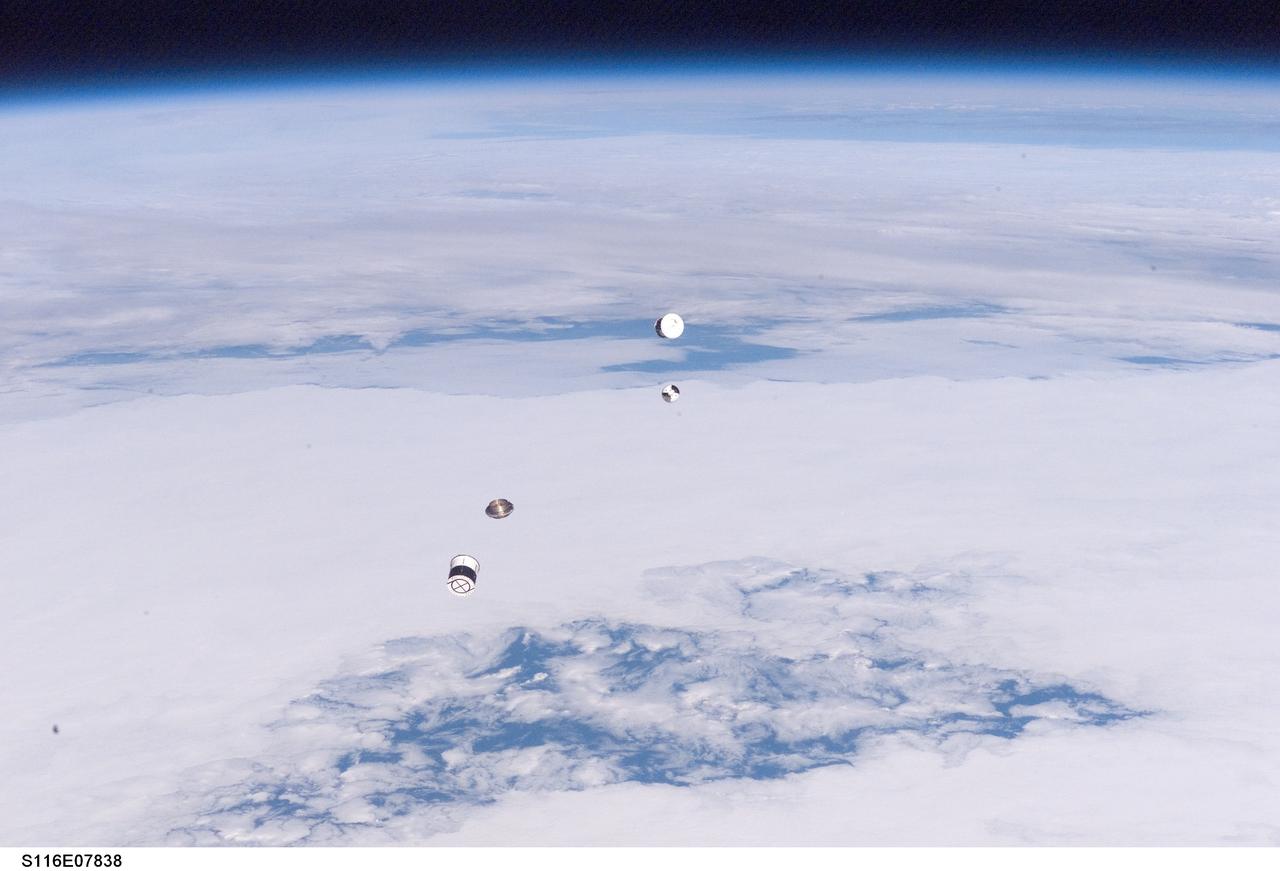 S116-E-07838 (21 Dec. 2006) --- As seen through windows on the aft flight deck of Space Shuttle Discovery, a Department of Defense pico-satellite known as Atmospheric Neutral Density Experiment (ANDE) is released from the shuttle's payload bay by STS-116 crewmembers. ANDE consists of two micro-satellites which will measure the density and composition of the low Earth orbit (LEO) atmosphere while being tracked from the ground. The data will be used to better predict the movement of objects in orbit.