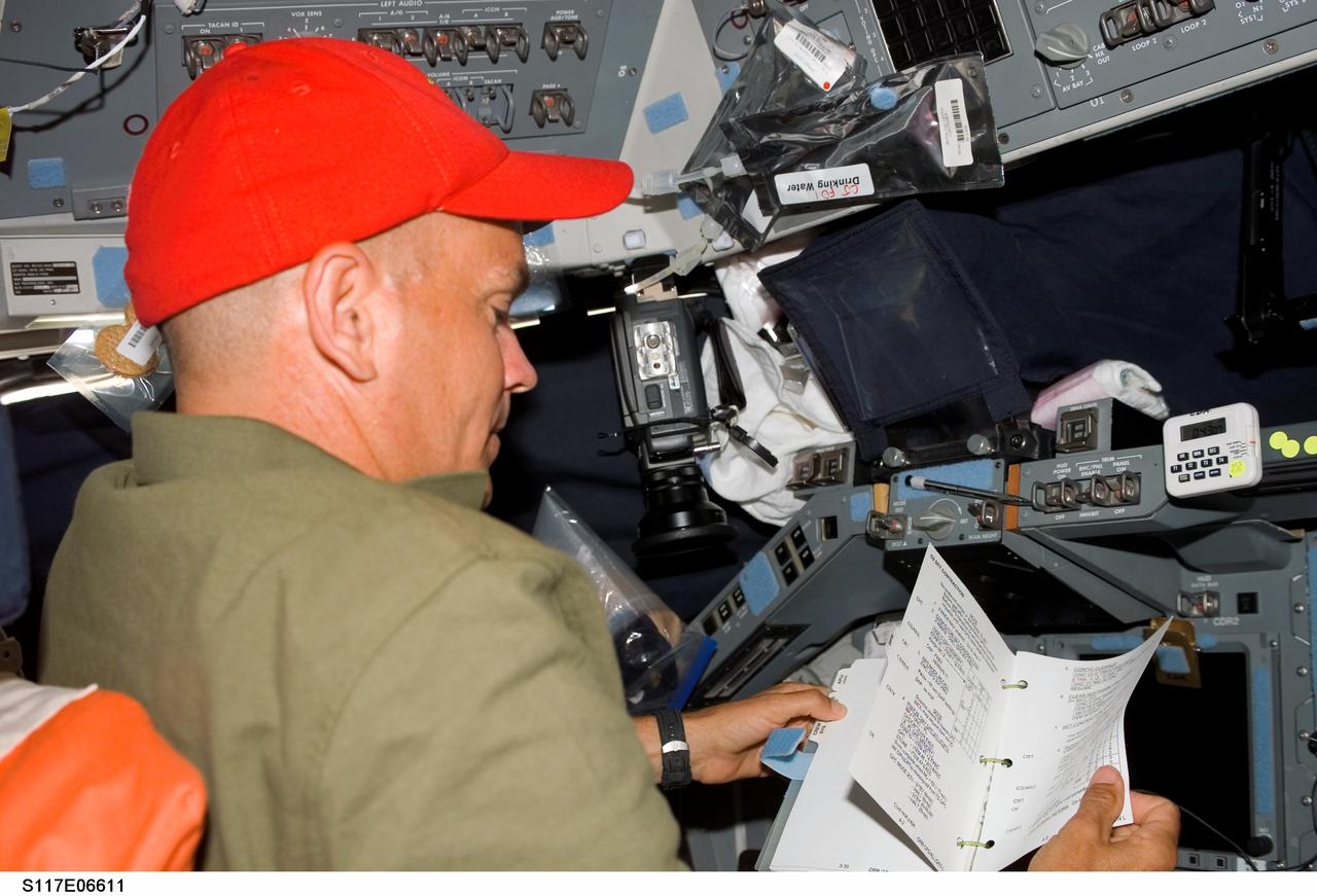S117-E-06611 (9 June 2007) --- Astronaut Rick Sturckow, STS-117 commander, looks over procedures checklists while seated at the commander's station on the flight deck of Space Shuttle Atlantis.