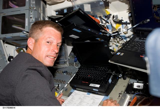 NASA image: Swanson works at laptop computer on the aft FD of STS-117 Space Shuttle Atlantis