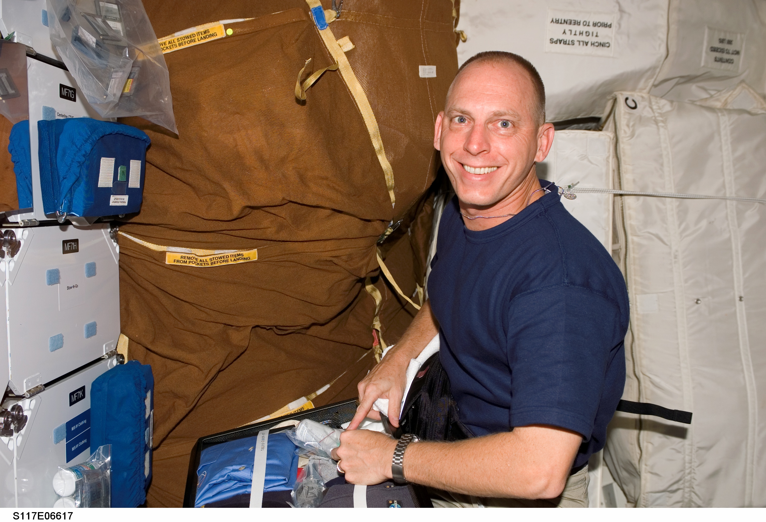 S117-E-06617 (9 June 2007) --- Astronaut Clayton Anderson, STS-117 mission specialist, works with stowage bags on the middeck of Space Shuttle Atlantis. After docking with the International Space Station, Anderson will join Expedition 15 in progress to serve as a flight engineer.