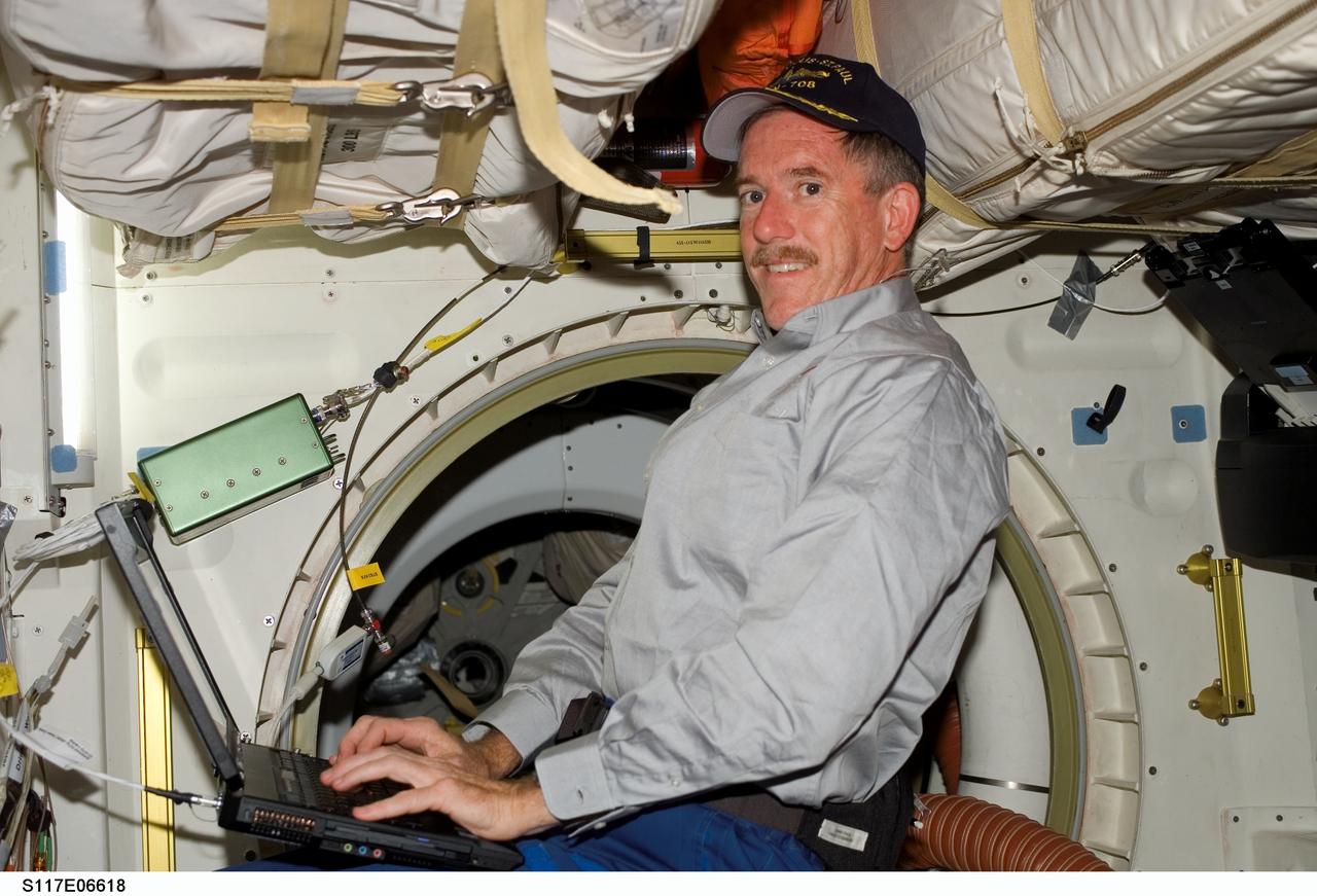 S117-E-06618 (9 June 2007) --- Astronaut Jim Reilly, STS-117 mission specialist, uses a computer on the middeck of Space Shuttle Atlantis.