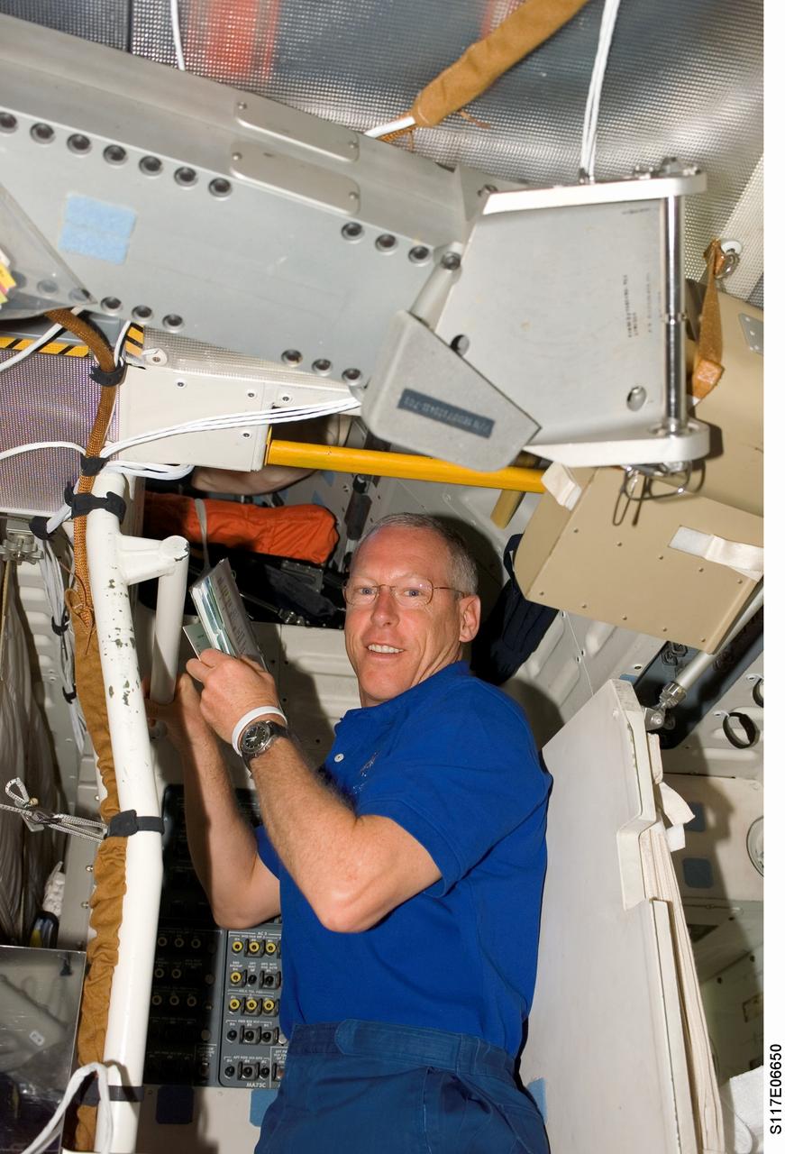 S117-E-06650 (9 June 2007) --- Astronaut Patrick Forrester, STS-117 mission specialist, looks over procedures checklists on the middeck of the Space Shuttle Atlantis.