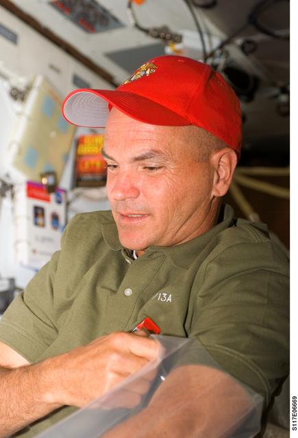 NASA image: Sturckow works with a plastic bag on the MDDK of STS-117 Space Shuttle Atlantis