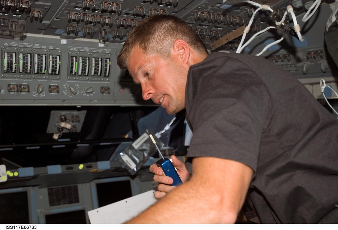S117-E-06733 (9 June 2007) --- Astronaut Steven Swanson, STS-117 mission specialist, uses a communication system on the flight deck of Space Shuttle Atlantis.