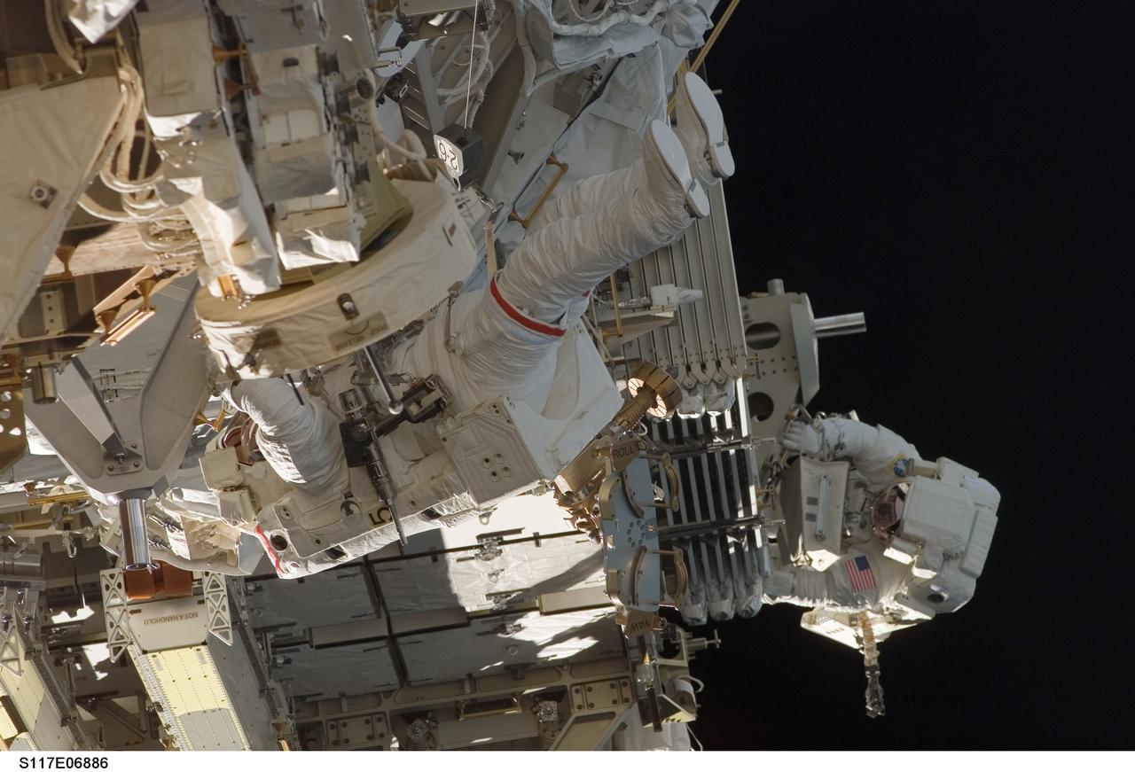 S117-E-06886 (11 June 2007) --- Astronauts Jim Reilly (center frame) and John "Danny" Olivas (bottom right), both STS-117 mission specialists, participate in the mission's first planned session of extravehicular activity (EVA), as construction resumes on the International Space Station. Among other tasks, Reilly and Olivas connected power, data and cooling cables between S1 and S3; released the launch restraints from and deployed the four solar array blanket boxes on S4 and released the cinches and winches holding the photovoltaic radiator on S4.