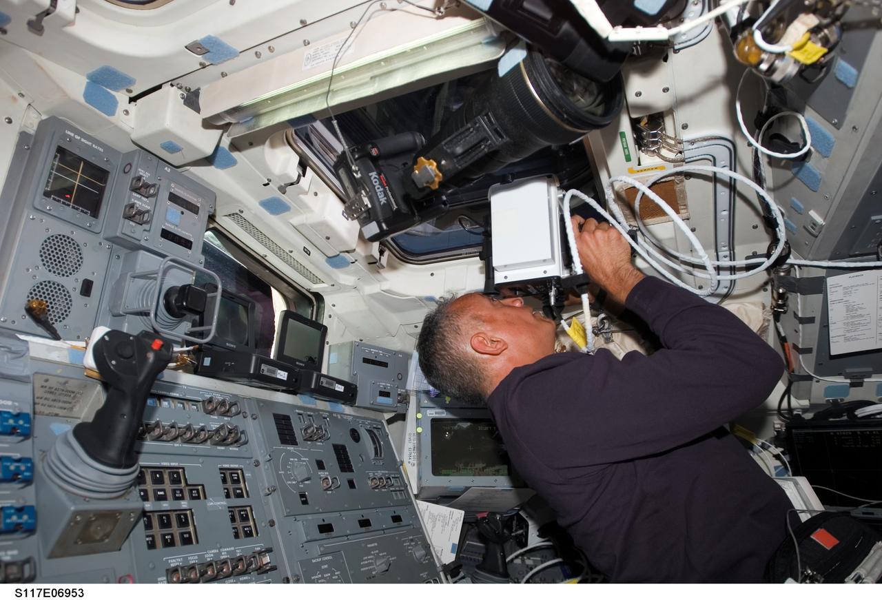S117-E-06953 (10 June 2007) --- Astronaut John "Danny" Olivas, STS-117 mission specialist, aims a laser range finder through one of the overhead windows on the aft flight deck of the Space Shuttle Atlantis at it approaches the International Space Station. This instrument is a regularly called-on tool during rendezvous operations with the station. The subsequent docking will allow the STS-117 astronauts and the Expedition 15 crew to team up for several days of key tasks in space.