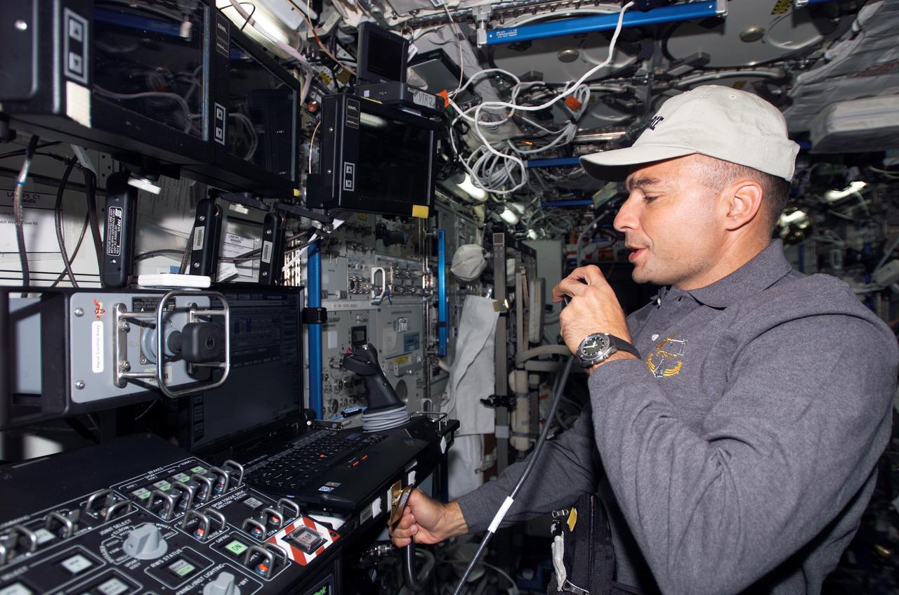 S117-E-07097 (12 June 2007) --- Astronaut Lee Archambault, STS-117 pilot, uses a communication system near the controls of the Space Station Remote Manipulator System (SSRMS) or Canadarm2 in the Destiny laboratory of the International Space Station during flight day five activities while Space Shuttle Atlantis was docked with the station.