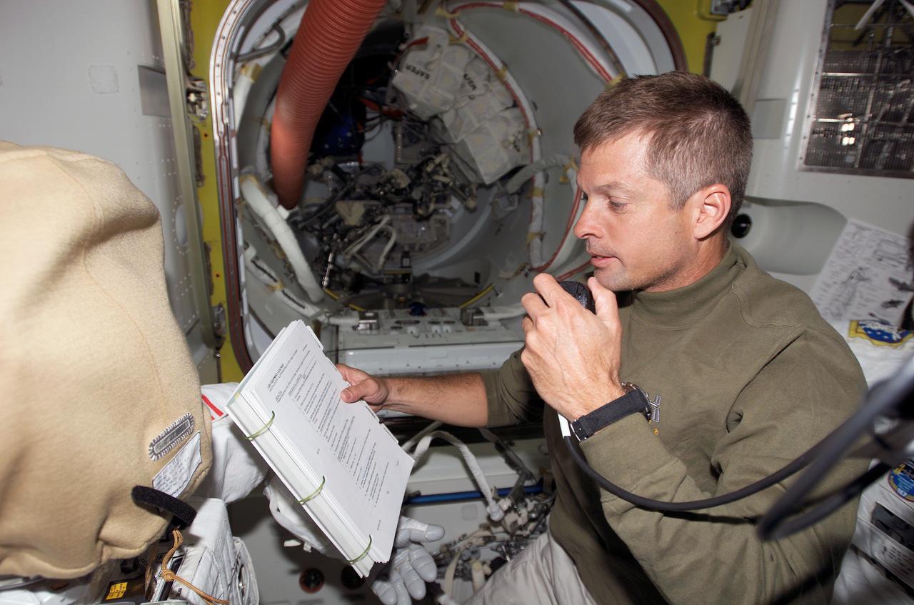 S117-E-07099 (12 June 2007) --- Astronaut Steven Swanson, STS-117 mission specialist, uses a communication system in the Quest Airlock of the International Space Station during flight day five activities while Space Shuttle Atlantis was docked with the station.