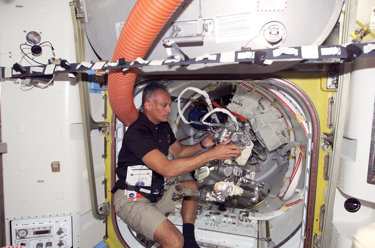 S117-E-07101 (12 June 2007) --- Astronaut John "Danny" Olivas, STS-117 mission specialist, works with extravehicular activity (EVA) tether lines in the Quest Airlock of the International Space Station while Space Shuttle Atlantis was docked with the station.