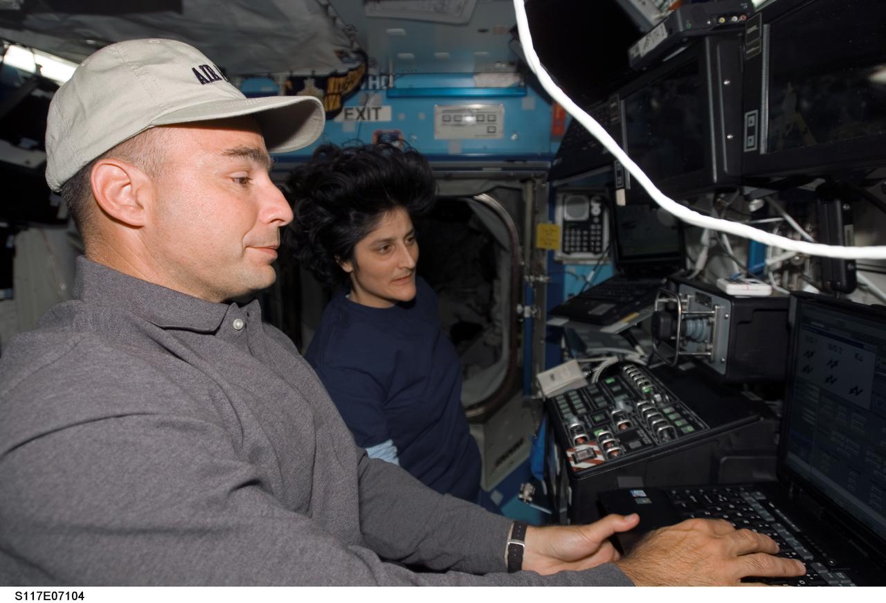 S117-E-07104 (12 June 2007) --- Astronauts Lee Archambault (foreground) and Sunita L. Williams, STS-117 pilot and mission specialist, respectively, work the controls of the Space Station Remote Manipulator System (SSRMS) or Canadarm2 in the Destiny laboratory of the International Space Station during flight day five activities while Space Shuttle Atlantis was docked with the station.