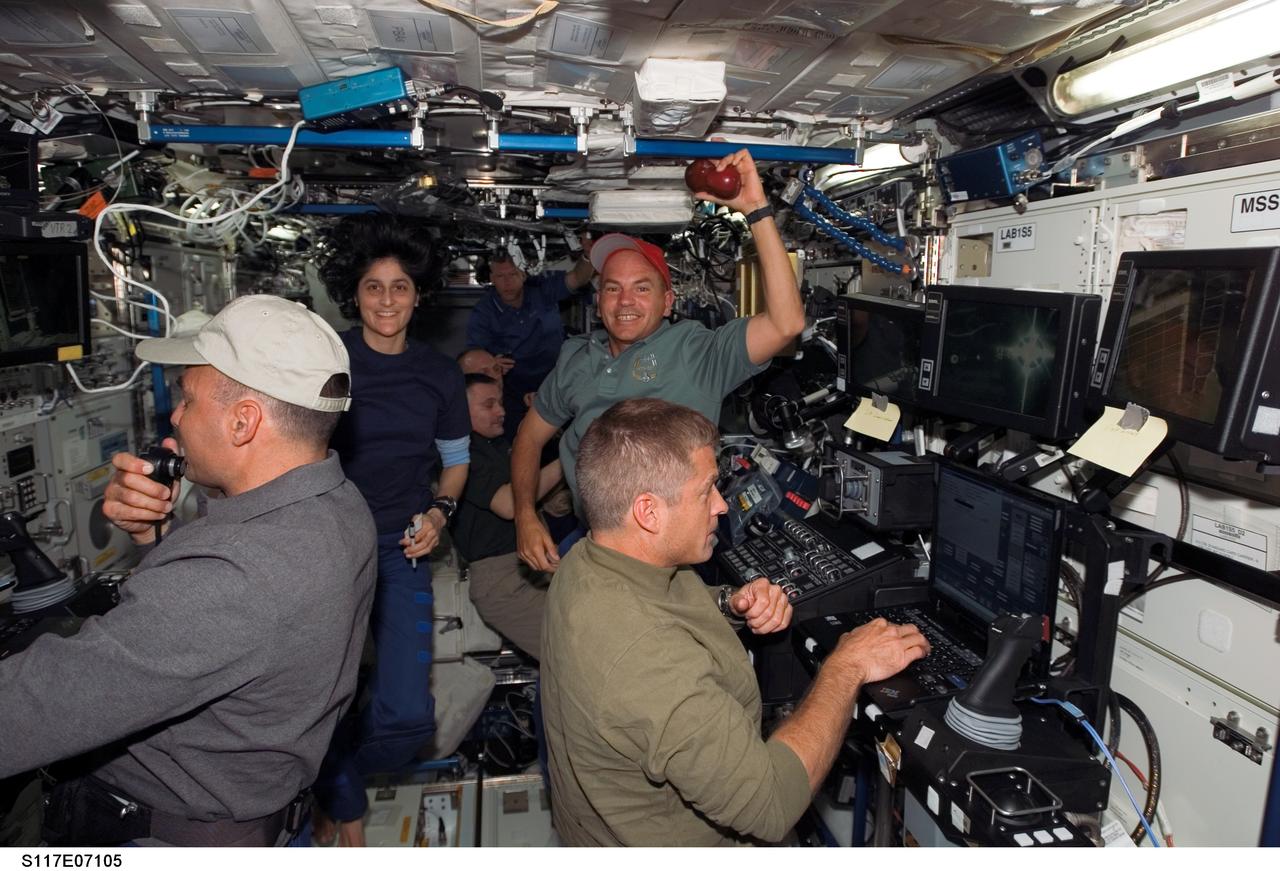 S117-E-07105 (12 June 2007) --- The STS-117 and Expedition 15 crewmembers work various tasks in the Destiny laboratory of the International Space Station during flight day five activities while Space Shuttle Atlantis was docked with the station. Pictured in the foreground (from the left) are astronauts Lee Archambault, STS-117 pilot; Sunita L. Williams, STS-117 mission specialist; Rick Sturckow, STS-117 commander; and Steven Swanson, STS-117 mission specialist. Visible in the background are cosmonaut Fyodor N. Yurchikhin, Expedition 15 commander representing Russia's Federal Space Agency; astronauts Clayton Anderson, Expedition 15 flight engineer; and Patrick Forrester, STS-117 mission specialist.