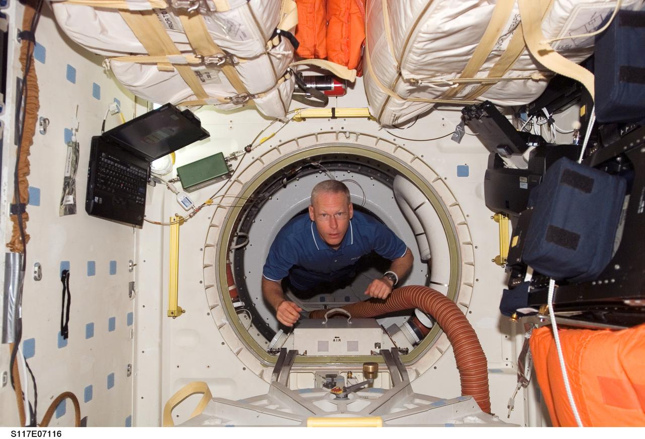 S117-E-07116 (12 June 2007) --- Astronaut Patrick Forrester, STS-117 mission specialist, floats through a hatch to the middeck of the Space Shuttle Atlantis during flight day five activities while docked with the International Space Station.