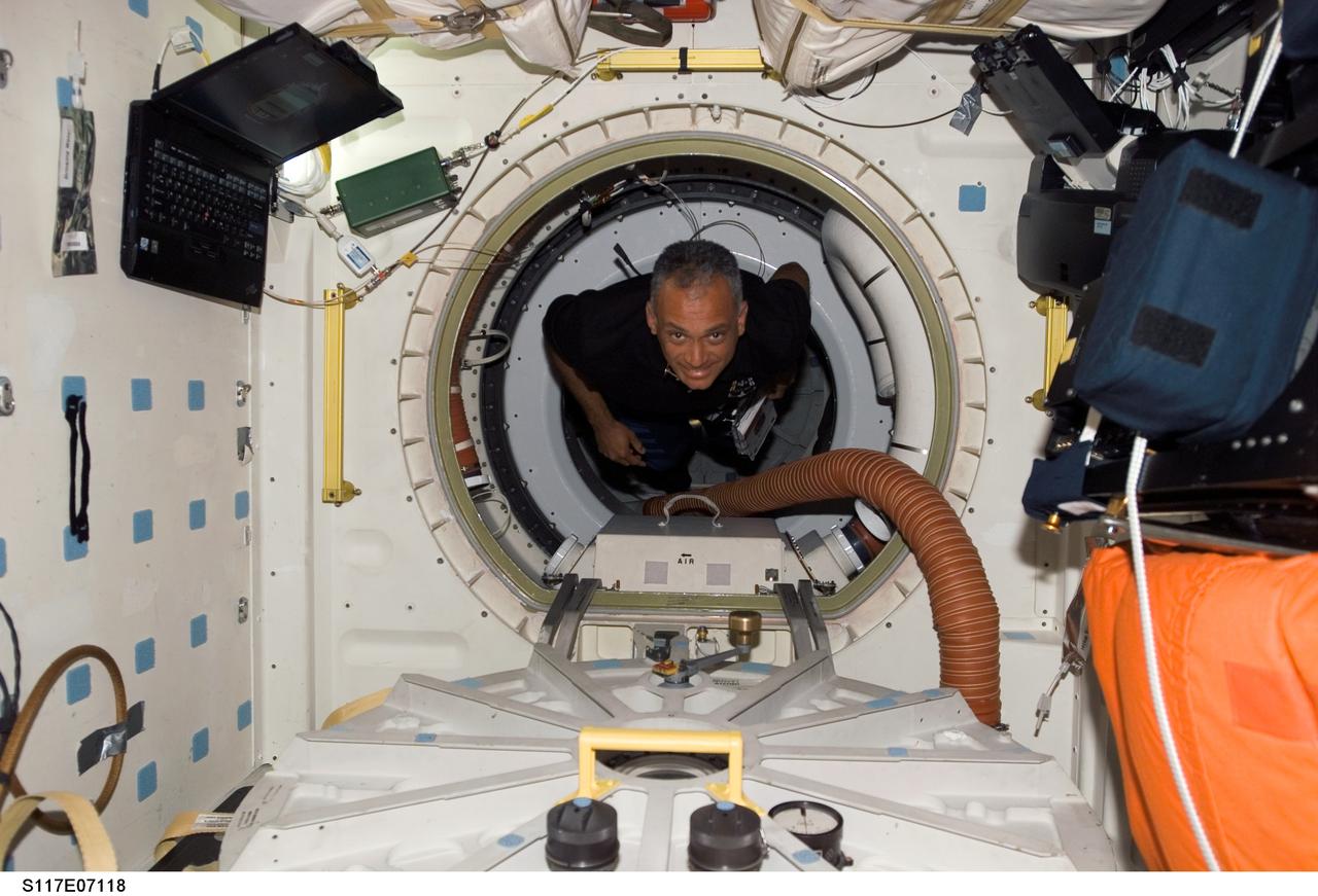 S117-E-07118 (12 June 2007) --- Astronaut John "Danny" Olivas, STS-117 mission specialist, floats through a hatch to the middeck of the Space Shuttle Atlantis during flight day five activities while docked with the International Space Station.
