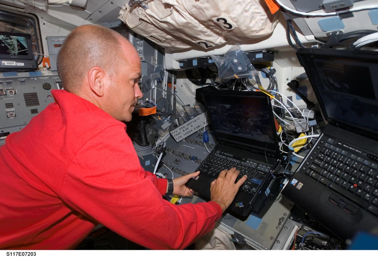 S117-E-07203 (13 June 2007) --- Astronaut Rick Sturckow, STS-117 commander, uses a computer on the flight deck of Space Shuttle Atlantis during flight day six activities while docked with the International Space Station.