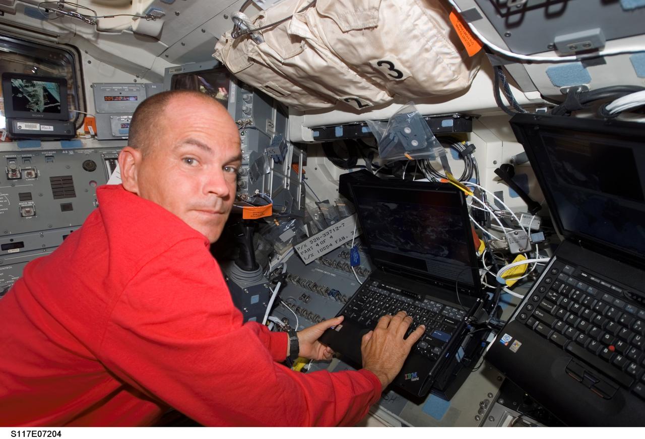 S117-E-07204 (13 June 2007) --- Astronaut Rick Sturckow, STS-117 commander, uses a computer on the flight deck of Space Shuttle Atlantis during flight day six activities while docked with the International Space Station.