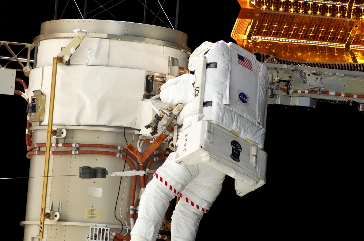 S117-E-07233 (13 June 2007) --- Astronauts Steven Swanson and Patrick Forrester (out of frame), both STS-117 mission specialists, participate in the mission's second planned session of extravehicular activity (EVA), as construction resumes on the International Space Station. Among other tasks, Forrester and Swanson removed all of the launch locks holding the 10-foot-wide solar alpha rotary joint in place and began the solar array retraction. Tethered to his Extravehicular Mobility Unit (EMU) spacesuit, a hockey-stick-shaped tool wrapped in insulating tape, is visible in front of Swanson.