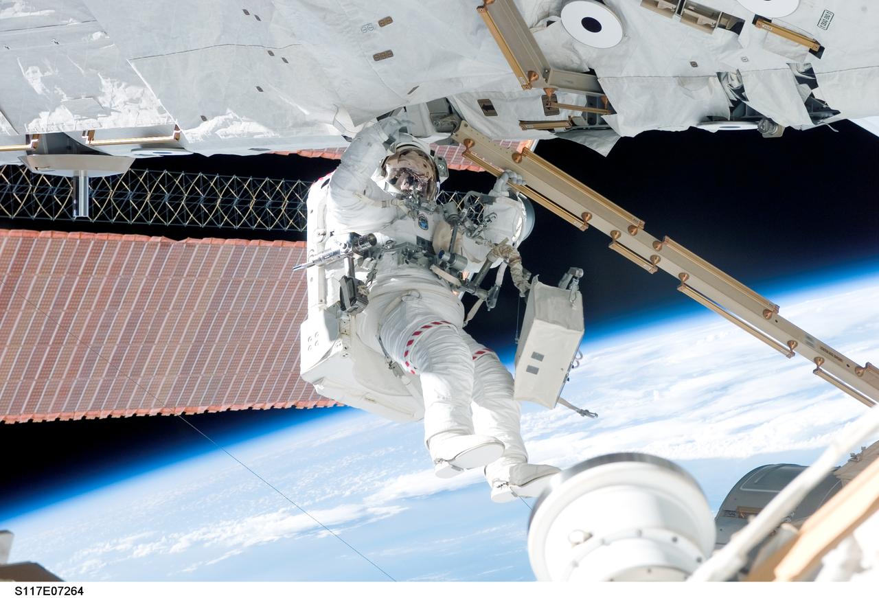 S117-E-07264 (13 June 2007) --- Astronauts Steven Swanson and Patrick Forrester (out of frame), both STS-117 mission specialists, participate in the mission's second planned session of extravehicular activity (EVA), as construction resumes on the International Space Station. Among other tasks, Forrester and Swanson removed all of the launch locks holding the 10-foot-wide solar alpha rotary joint in place and began the solar array retraction.