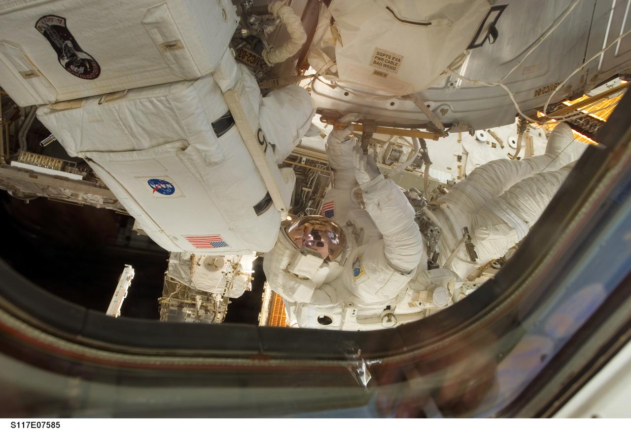 S117-E-07585 (15 June 2007) --- Astronauts Jim Reilly (left) and John (Danny) Olivas, both STS-117 mission specialists, are photographed by a crewmate inside the spacecraft in the midst of a 7 hour, 58-minute spacewalk. The two each performed solo and shared tasks on their second and the mission's third extravehicular activity. Olivas is holding onto a handrail on the Destiny lab.
