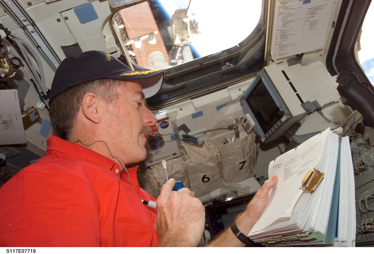 S117-E-07719 (17 June 2007) --- On the flight deck of Space Shuttle Atlantis, astronaut Jim Reilly, STS-117 mission specialist, talks to ground controllers while supporting two spacewalking crewmates during the mission's fourth and final session of extravehicular activity (EVA) while docked with the International Space Station.