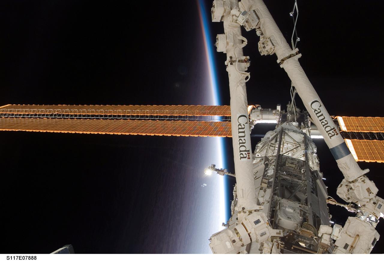 S117-E-07888 (18 June 2007) --- The International Space Station's Canadarm2, or Space Station Remote Manipulator System (SSRMS) and solar array wings are featured in this image photographed by a crewmember on the station while Space Shuttle Atlantis was docked with the orbital complex. The blackness of space and Earth's horizon provides the backdrop for the scene.