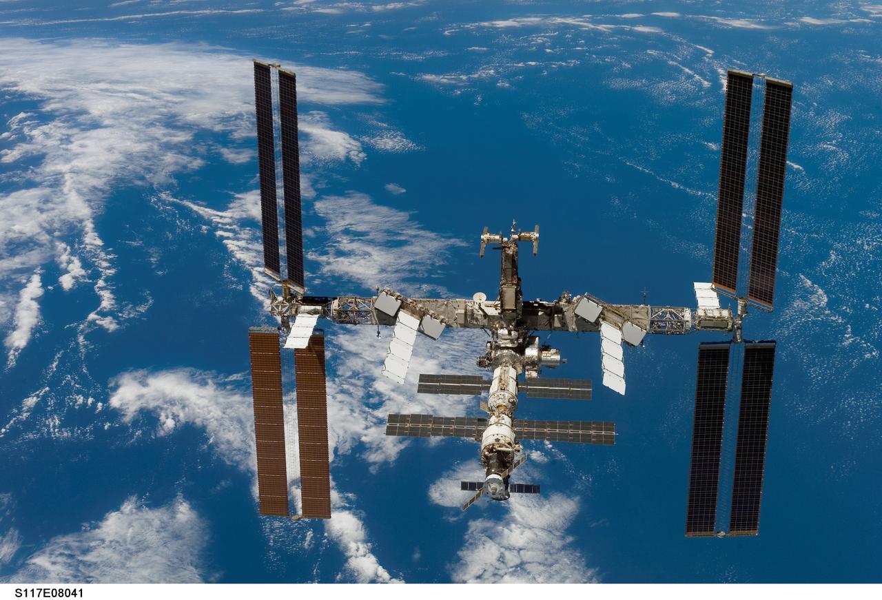 S117-E-08041 (19 June 2007) --- Backdropped by a blue and white Earth, the International Space Station moves away from the Space Shuttle Atlantis. Earlier the STS-117 and Expedition 15 crews concluded about eight days of cooperative work onboard the shuttle and station. Undocking of the two spacecraft occurred at 9:42 a.m. (CDT) on June 19, 2007. Astronaut Lee Archambault, STS-117 pilot, was at the controls for the departure and fly-around, which gave Atlantis' crew a look at the station's new expanded configuration.