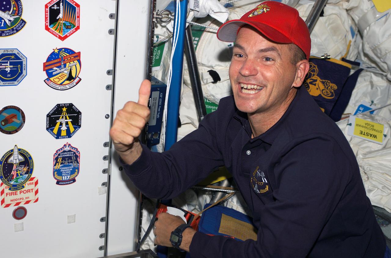 S117-E-09480 (17 June 2007) --- Astronaut Rick Sturckow, STS-117 commander, gives a "thumbs-up" signal after placing the STS-117 mission insignia along with others in the Unity node of the International Space Station.