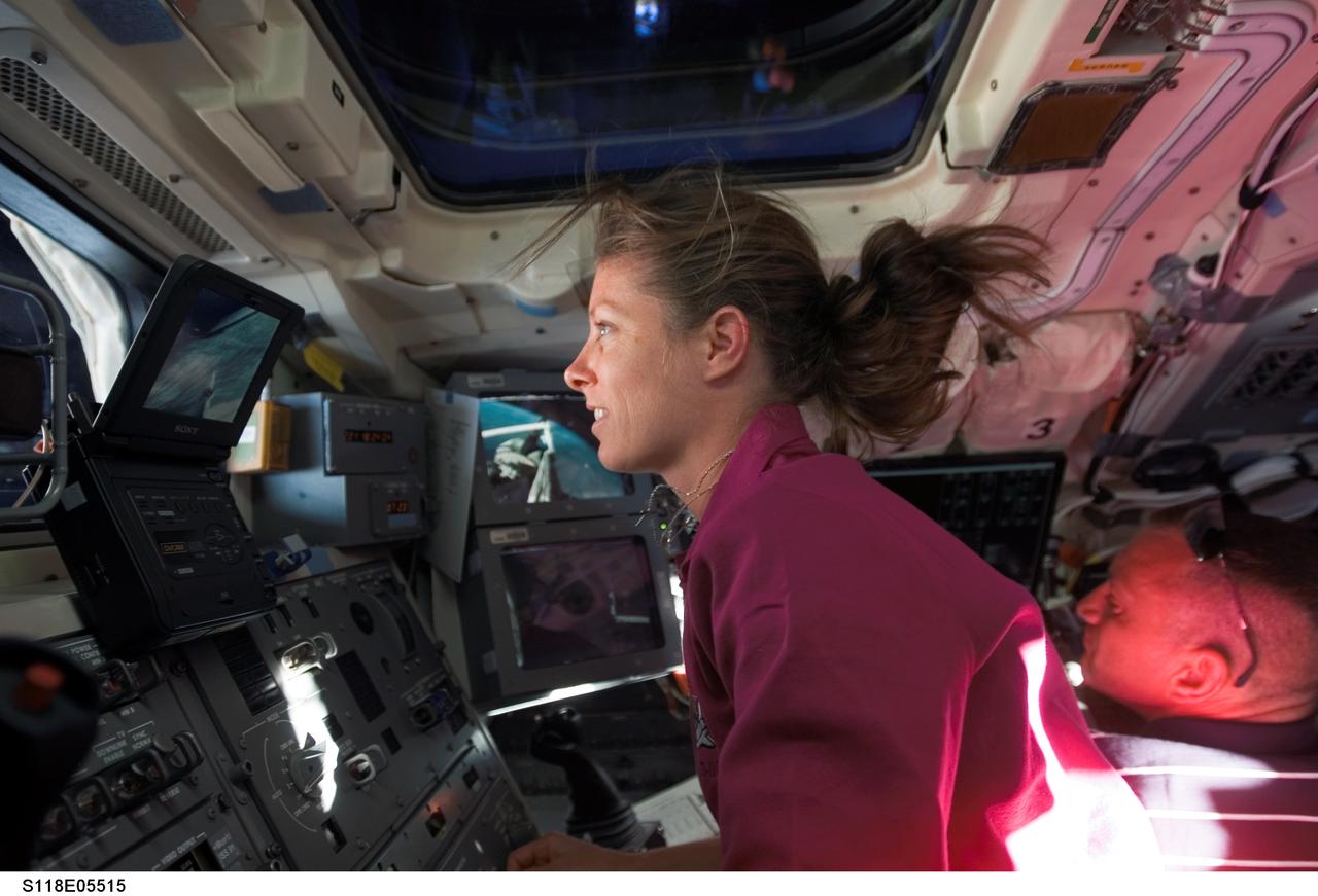 S118-E-05515 (9 Aug. 2007) --- Astronaut Tracy Caldwell, STS-118 mission specialist, works the controls on the aft flight deck of Space Shuttle Endeavour during flight day two activities. Astronaut Charlie Hobaugh, pilot, is visible at lower right.