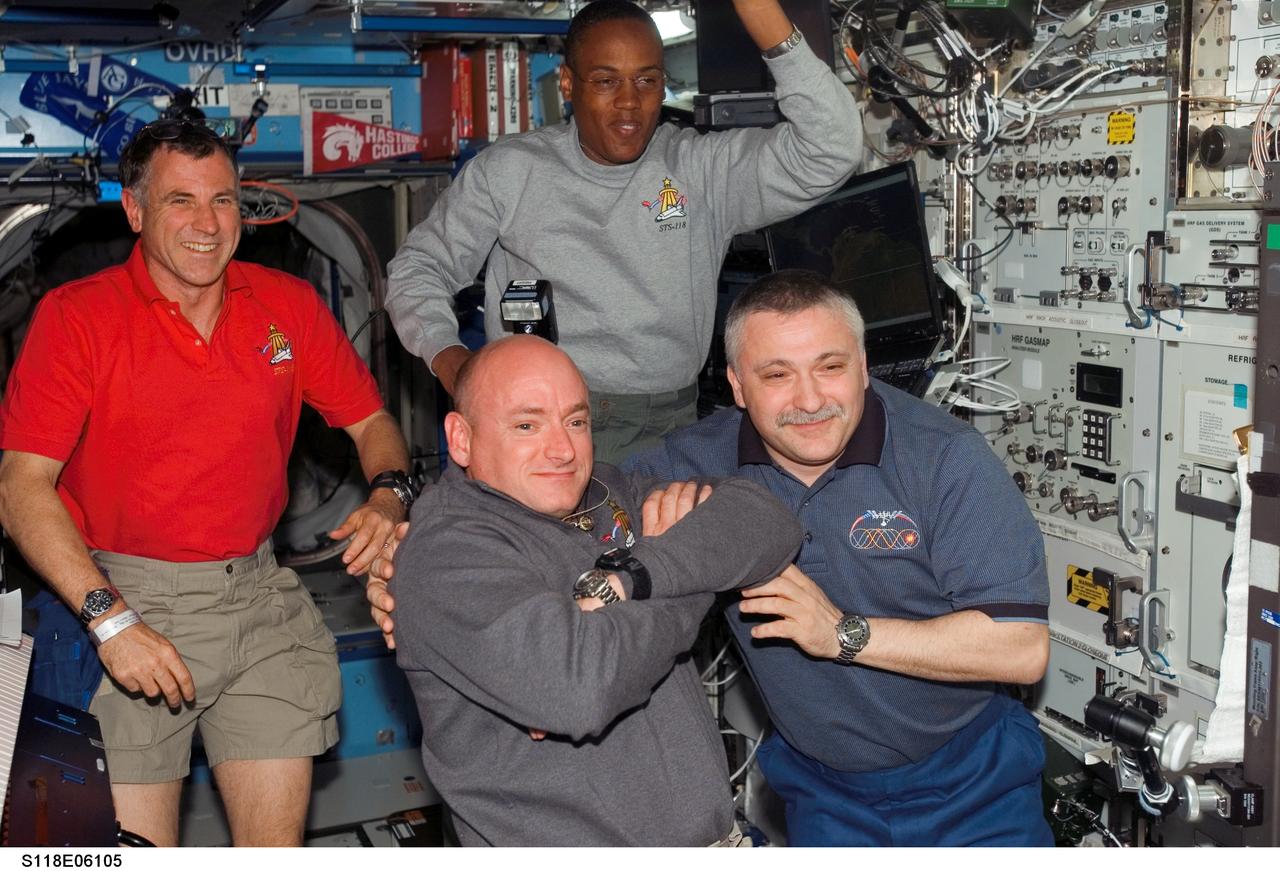 S118-E-06105 (10 Aug. 2007) --- A shuttle crewmember took a picture of the reunion of two commanders soon after hatch opening on the International Space Station as the orbital outpost's population immediately expanded from three to ten. In the foreground are astronaut Scott Kelly, STS-118 commander, and cosmonaut Fyodor Yurchikhin, Expedition 15 commander representing Russia's Federal Space Agency. Looking in the background are astronauts Dave Williams (left), representing the Canadian Space Agency, and Alvin Drew, both STS-118 mission specialists.