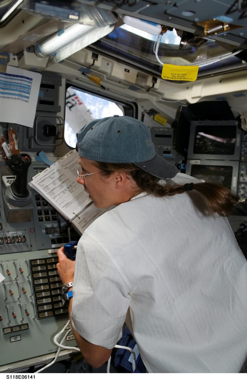S118-E-06141 (11 Aug. 2007) --- Astronaut Tracy Caldwell, STS-118 mission specialist, works the controls of the shuttle's remote manipulator system (RMS) robotic arm from the aft flight deck of Space Shuttle Endeavour in support of the mission's first planned session of extravehicular activity (EVA) while docked with the International Space Station.