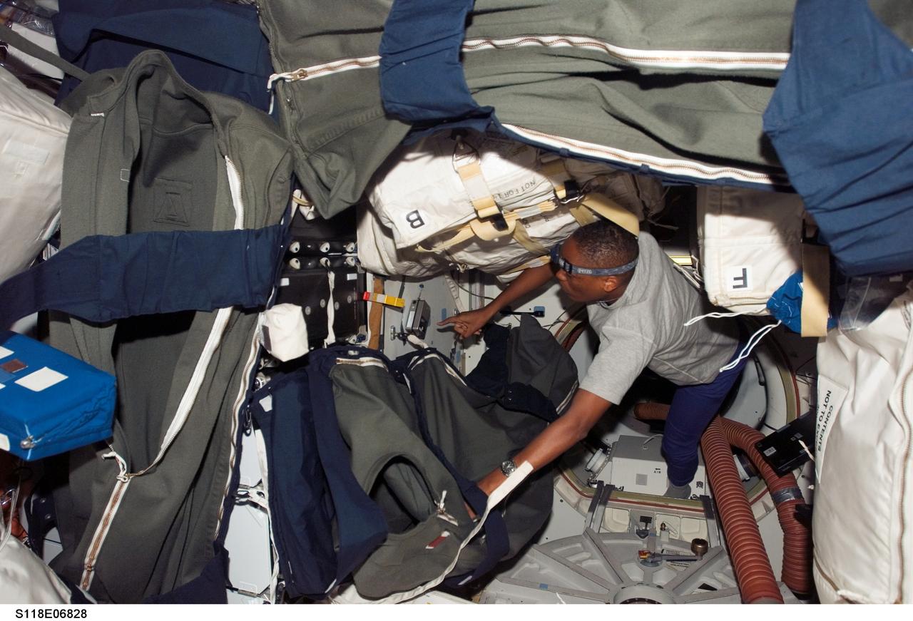 S118-E-06828 (11 Aug. 2007) --- Astronaut Alvin Drew, STS-118 mission specialist,  works near a hatch of Space Shuttle Endeavour while docked with the International Space Station during flight day four activities. Sleeping bags are visible in the foreground.