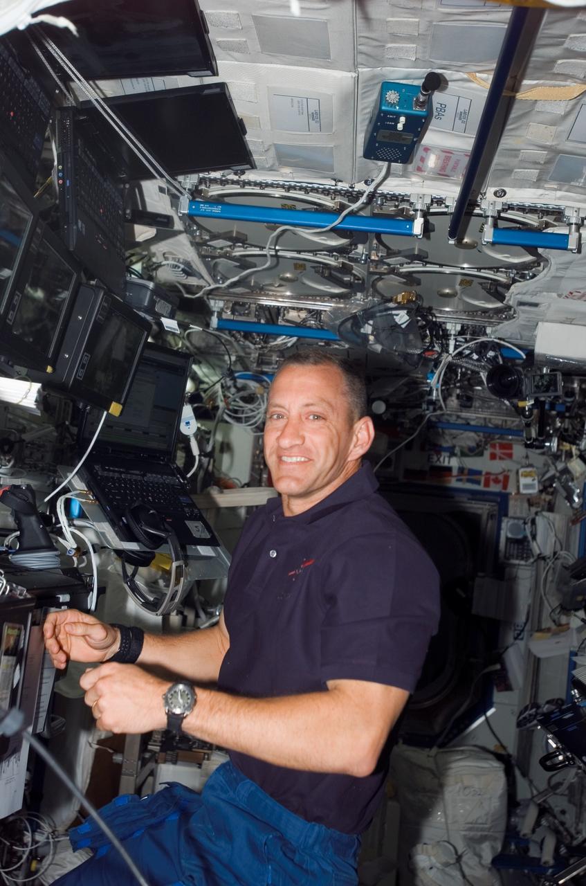 S118-E-06877 (12 Aug. 2007) --- Astronaut Charlie Hobaugh, STS-118 pilot, pauses for a photo while working the controls of the Space Station Remote Manipulator System (SSRMS) or Canadarm2 in the Destiny laboratory of the International Space Station while Space Shuttle Endeavour remains docked with the station.