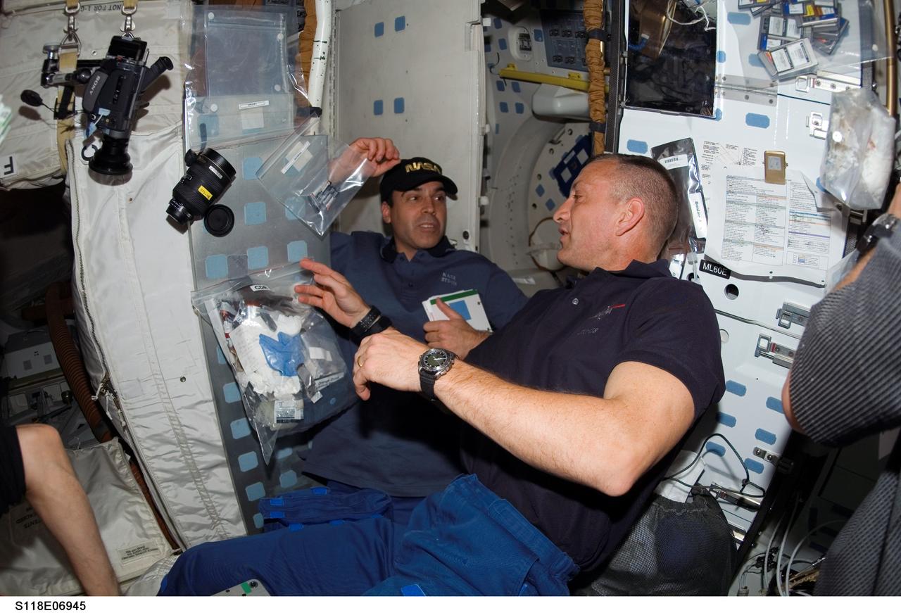 S118-E-06945 (12 Aug. 2007) --- Astronauts Charlie Hobaugh (foreground), STS-118 pilot, and Rick Mastracchio, mission specialist, photographed on the middeck of Space Shuttle Endeavour while docked with the International Space Station during flight day five activities.