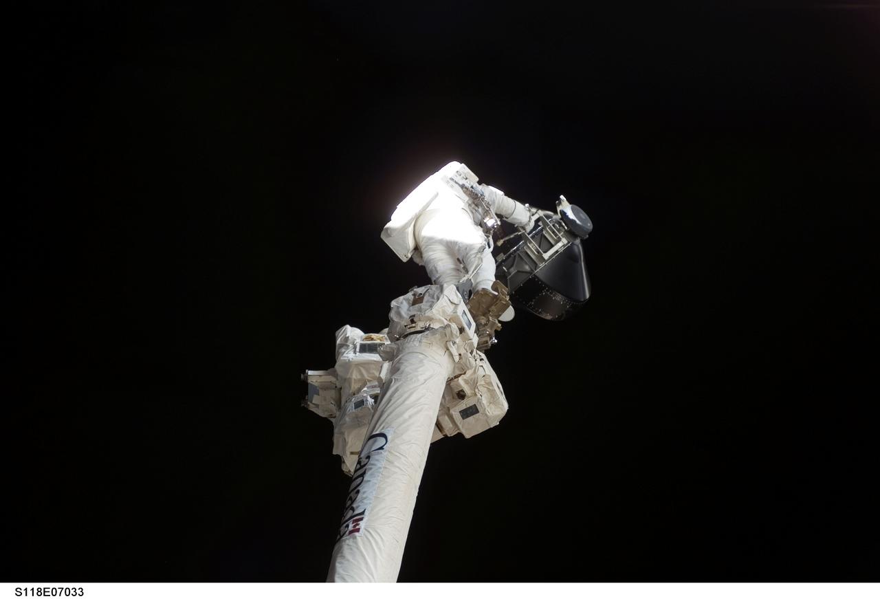 S118-E-07033 (13 Aug. 2007) --- While anchored to the foot restraint on the Canadarm2, astronaut Dave Williams, STS-118 mission specialist representing the Canadian Space Agency, participates in the mission's second planned session of extravehicular activity (EVA) as construction and maintenance continue on the International Space Station. During the 6-hour, 28-minute spacewalk, Williams and astronaut Rick Mastracchio (out of frame), mission specialist, removed a faulty control moment gyroscope (CMG-3) and installed a new CMG into the station's Z1 truss. The failed CMG will remain at its temporary stowage location on the station's exterior until it is returned to Earth on a later shuttle mission. The new gyroscope is one of four CMGs that are used to control the station's attitude in orbit.