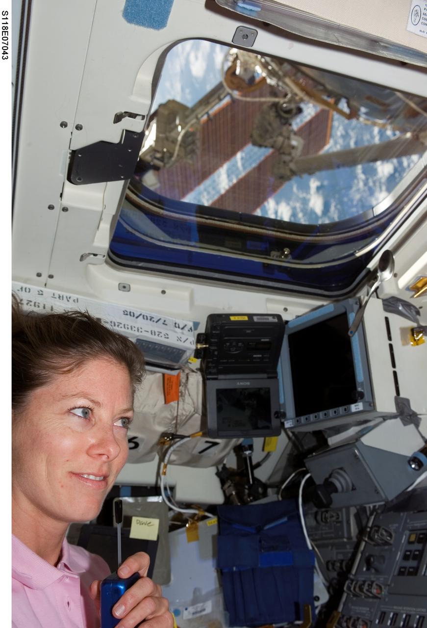 S118-E-07043 (13 Aug. 2007) --- Astronaut Tracy Caldwell, STS-118 mission specialist, uses a communication system near the aft flight deck of Space Shuttle Endeavour during flight day six activities while docked with the International Space Station.