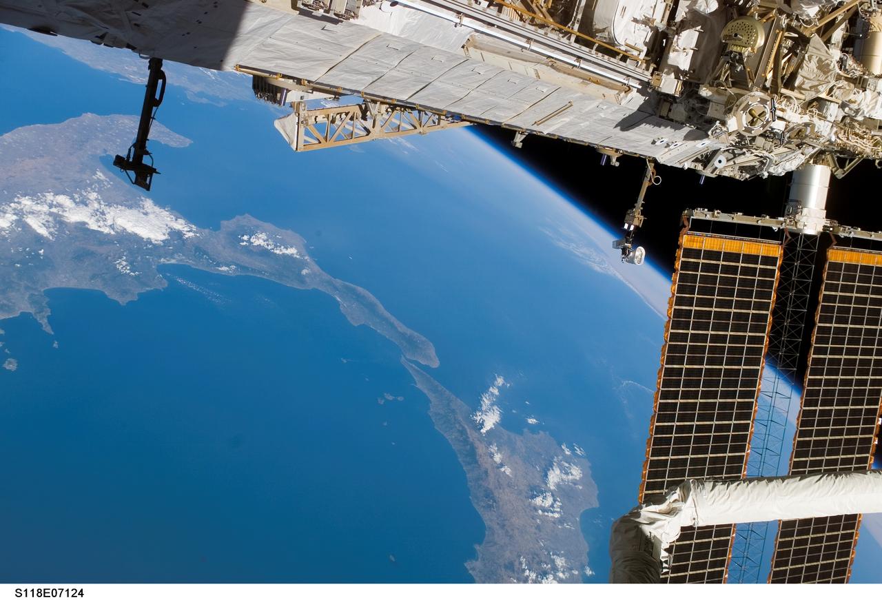 S118-E-07124 (14 Aug. 2007) --- A portion of the International Space Station frames this view of the lower portion of Italy and a portion of Sicily, photographed by a STS-118 crewmember while Space Shuttle Endeavour remains docked with the station.